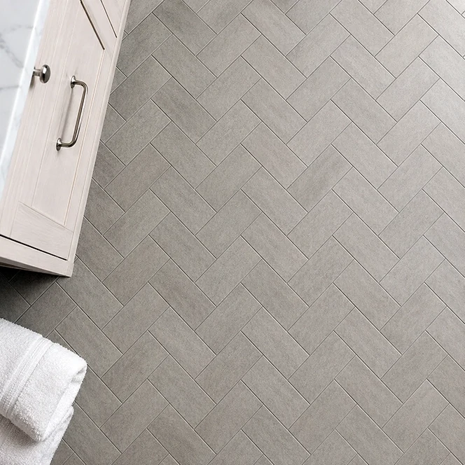 A newly finished bathroom floor in herringbone tile pattern.
